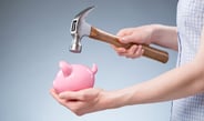 bigstock-Woman-Breaking-Open-A-Piggy-Ba-57085556