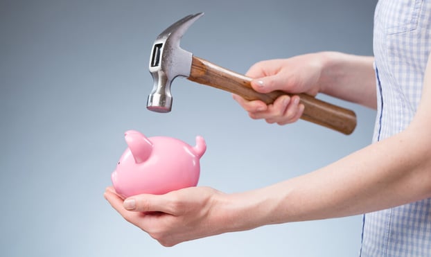 bigstock-Woman-Breaking-Open-A-Piggy-Ba-57085556